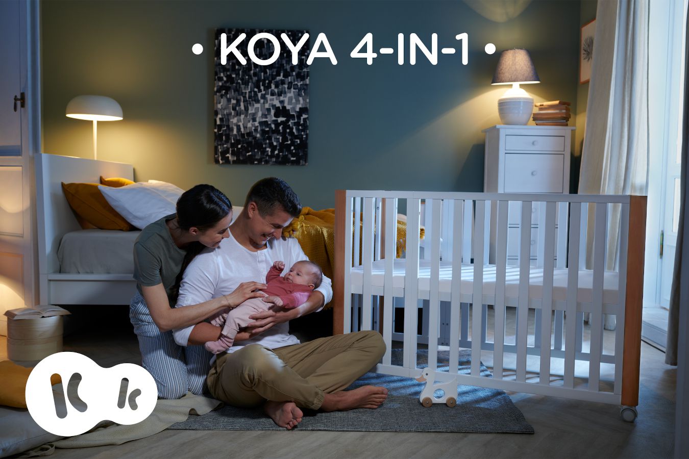 En la casa, los padres están sentados junto con un bebé al lado de la cuna KOYA, el nombre pone KOYA 4IN1.